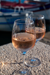 Glasses of cold rose Cote de Provence wine in old fisherman boats and yacht harbour in Saint-Tropez, summer vacation on French Riviera in Provence, France
