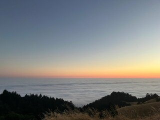sunset on mountain over clouds