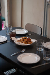dinner table with chicken nuggets, sausages, fries and salad.