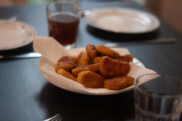 dinner table with chicken nuggets, sausages, fries and salad.