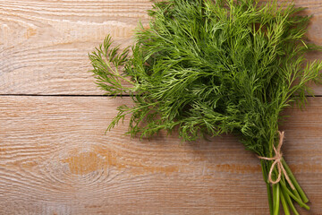 Bunch of fresh dill on wooden table, top view. Space for text
