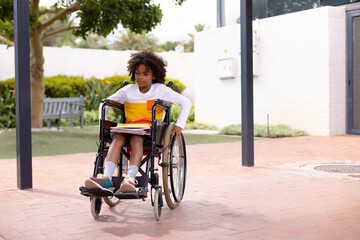 Obraz premium Happy african american schoolboy in wheelchair at school