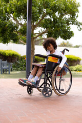 Portrait of happy african american schoolboy in wheelchair at school