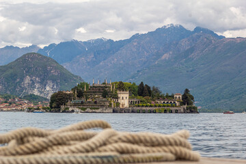 Isola Bella picture taken from the boat with visible boat rope.
Majestic island on lake Maggiore with Alps visible in background