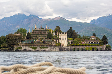 Isola Bella picture taken from the boat with visible boat rope.
Majestic island on lake Maggiore with Alps visible in background