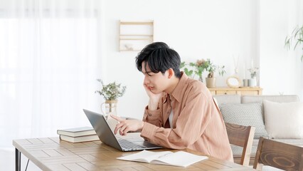パソコンを見て考える男性