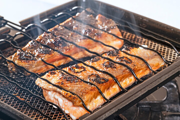 Grilled salmon cutlet on a grill grate.