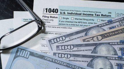 US tax documents with fake US currency and eyeglasses