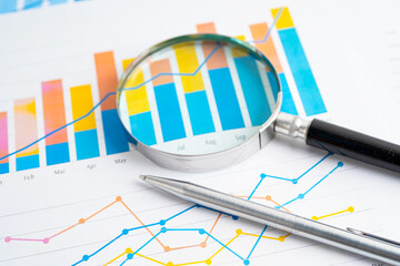 Obraz premium Magnifying glass on graph. Finance business and trading.