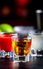 Golden tequila, sangrita and fresh lime juice on black bar counter