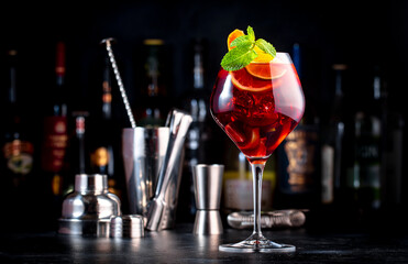 Summer sangria cocktail drink with red wine, peach, plum, orange, lime and ice. Black background