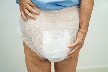 Asian elderly woman wearing diaper for loss of bladder urinary incontinence control.