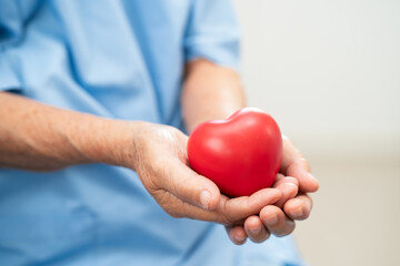 Asian doctor give red heart to elderly woman in her hand, heart Attack.