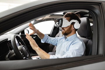 Businessman uses virtual reality headset while sitting inside vehicle at dealership. Concept of innovative technology in automotive industry virtual test drives and immersive experiences for customers