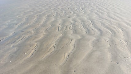Sand texture on the beach in the evening light. Natural background.