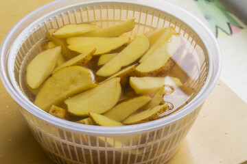 Soaking potato wedges in a bowl of salt water,for flavor and crispyness