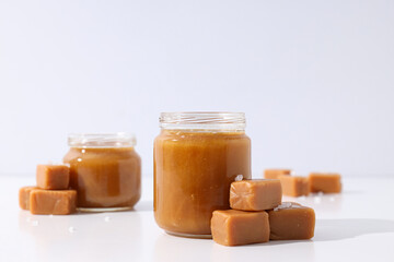 Cubes of salted caramel with caramel in a jar