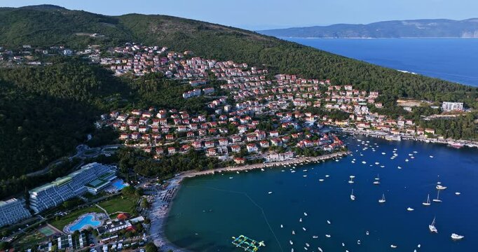 Aerial view of a coastline full of holiday homes, sunny evening in Rabac, Croatia