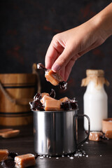 Cubes of salted caramel in a metal cup with milk in a bottle