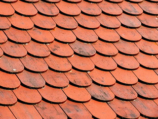 red round tiles on the roof, traditional red roof, close up and details, background of european architecture. 