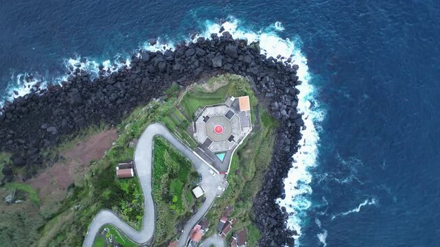 Ocean shore at Azores Portugal, drone rotates above lighthouse architecture