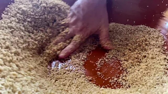 hands close up chef making cous cous traditional North African dish from semolina durum wheat slow motion