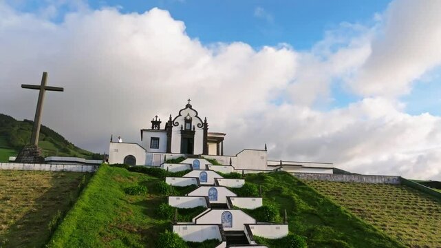 White chapel above green hills of Portugal, aerial drone fly daylight in Azores, Ermida de Nossa Senhora da Paz