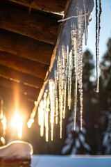 Crystal-clear icicles hanging from the eaves of a cabin, shimmering in the winter sun like fragile works of art, Generative AI