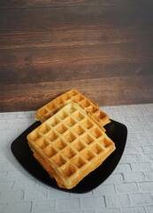 Homemade Waffles, delicious, close up. Waffle is a dish made from leavened batter or dough that is cooked between two plates that are patterned to give a characteristic size, shape, and surface impres