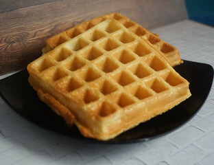 Homemade Waffles, delicious, close up. Waffle is a dish made from leavened batter or dough that is cooked between two plates that are patterned to give a characteristic size, shape, and surface impres