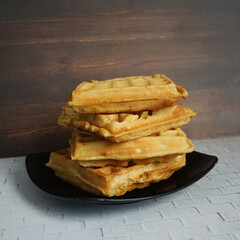 Homemade Waffles, delicious, close up. Waffle is a dish made from leavened batter or dough that is cooked between two plates that are patterned to give a characteristic size, shape, and surface impres