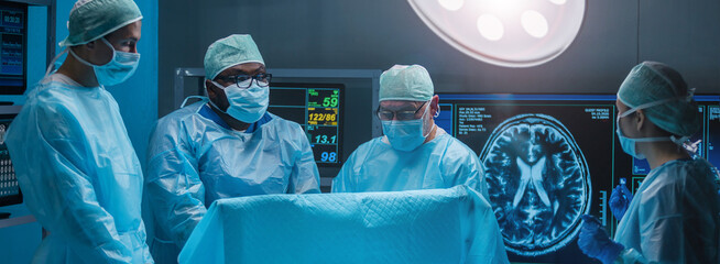 Team of medical doctors performs surgical operation in modern operating room using high-tech...