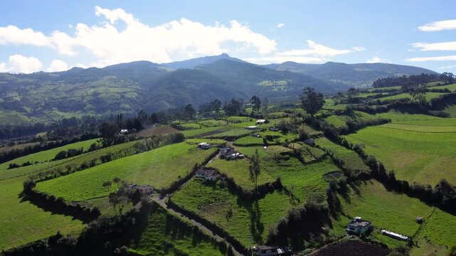 Aerial drone flight over a guitig neighborhood in the province of Pichincha on a sunny day with clouds over the mountains, slomotion copy space