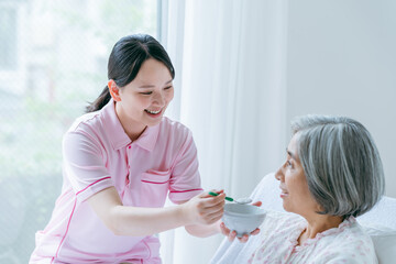 介護施設で暮らすシニア女性と若い介護士