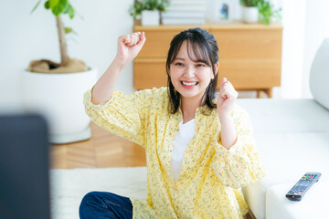 リビングでテレビを見る若い女性