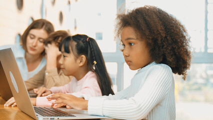 African girl play laptop with diverse friend learning prompt at STEM technology class....