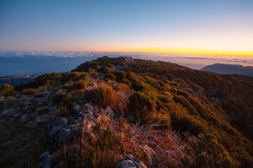 Hiking on the highest peak of Madeira Pico Ruivo next to the cottage Abrigo do Pico Ruivo. Views of the surrounding mountains lanscape during sunrise