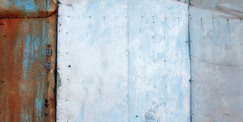 Rustic Elegance: Weathered Blue Metal Door. The Allure of Faded Paint and Oxidized Surfaces in an Industrial Setting