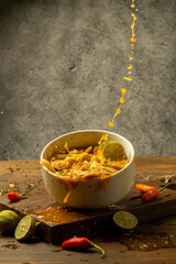 Indonesian spicy soup food on a white bowl with a freeze and levitation photo concept, dark brown wooden background