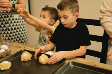 Fototapeta premium Young boys prepping traditional Italian Easter Egg Baskets with family