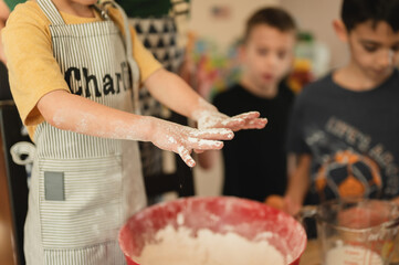 Close up of young boy's hands covered in flour from baking with family