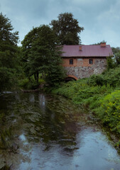 Obraz premium Brick mill in Mazury near river during summer time in Poland