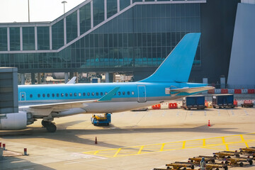 Blue airplane jet connected to terminal via jet bridge