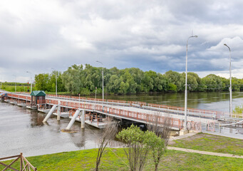 Fototapeta premium A bridge over a river with a green building in the background
