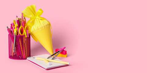 Cup with stationery and school cone on pink background