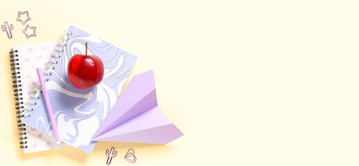 Apple, paper plane and different school stationery on beige background with space for text