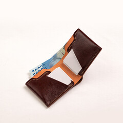 various leather wallets in various colors and cartoon cases with plain white backgrounds