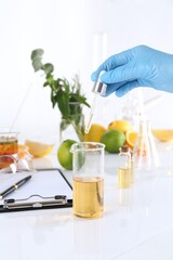 Aromatherapy product. Scientist developing essential oils at white table in laboratory, closeup