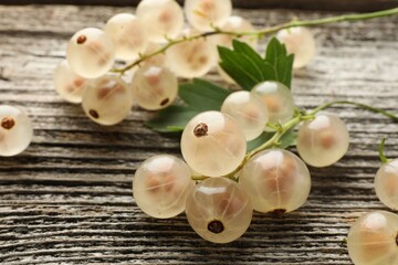 Fresh white currant berries and green leaf on wooden table, closeup