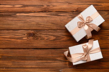 Gift boxes tied up with beige ribbon on wooden background. Top view